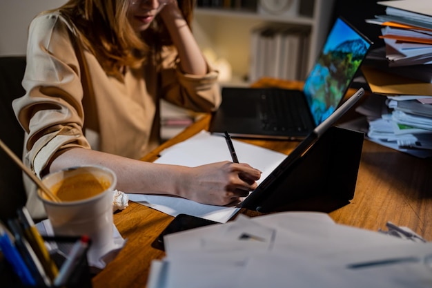 Aziatische zakenvrouw die 's nachts online werkt. Druk en uitgeput van overwerk thuis