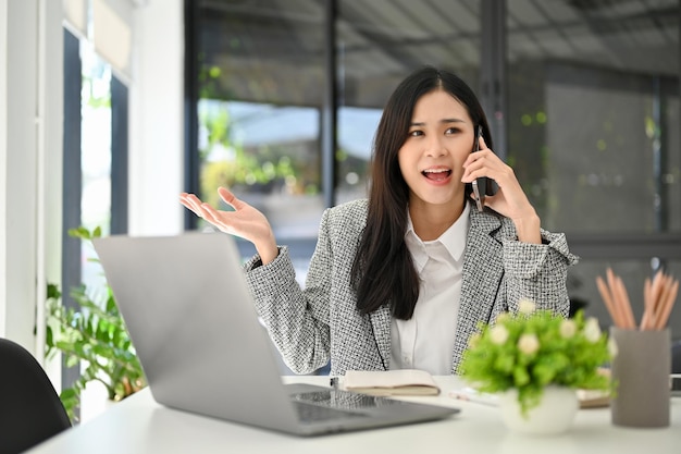 Aziatische zakenvrouw die telefonisch praat met haar klant die zaken doet via de oproep