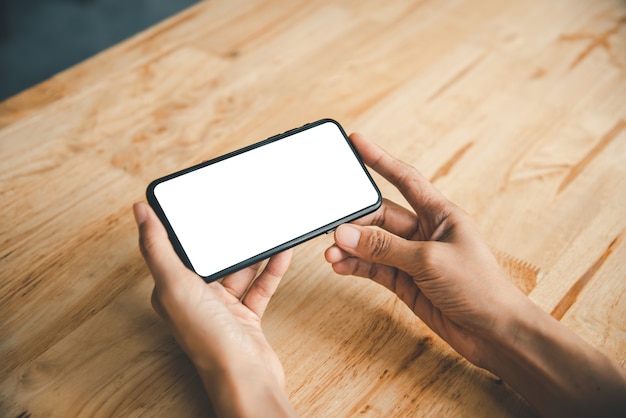 Aziatische zakenvrouw hand gebruiken en aanraken van slimme telefoon met wit leeg leeg scherm.