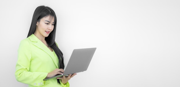 Aziatische zakenvrouw in pak werken op computer laptop geïsoleerd op witte achtergrond Zelfverzekerde lachende gelukkig Aziatische zakenvrouw Zakelijke financiën en werkgelegenheid vrouwelijke succesvolle ondernemers concept