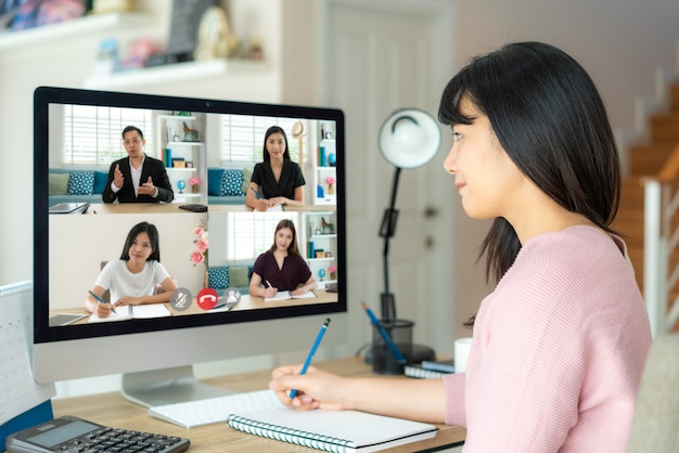 Aziatische zakenvrouw praten met haar collega's over plan in videoconferentie.