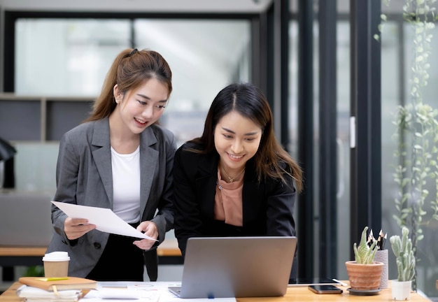 Aziatische zakenvrouw twee bespreken vergadering kantoor laptop werk jong team gelukkig