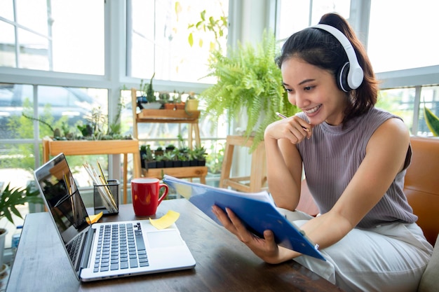 Aziatische zakenvrouwen gebruiken notebooks en dragen een koptelefoon voor online vergaderingen en thuiswerken.