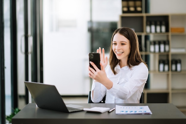 Aziatische zakenvrouwen zijn opgetogen en blij met het werk dat ze doen op hun tablet-laptop en het maken van aantekeningen op kantoorxA