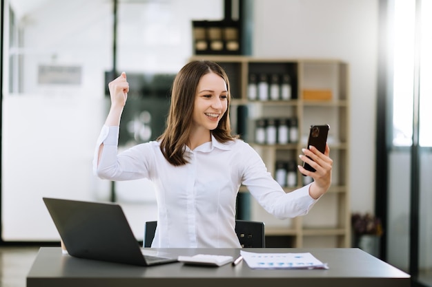 Aziatische zakenvrouwen zijn opgetogen en blij met het werk dat ze doen op hun tablet-laptop en het maken van aantekeningen op kantoorxA