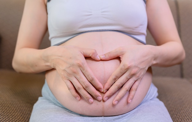 Aziatische zwangere vrouw blijft alleen thuis. familie levensstijl van de zwangerschap.