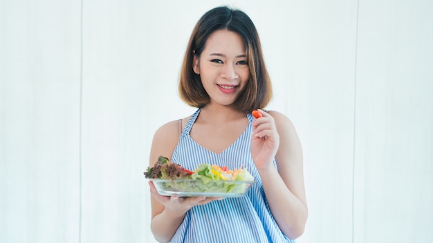 Aziatische zwangere vrouw is het eten van salade