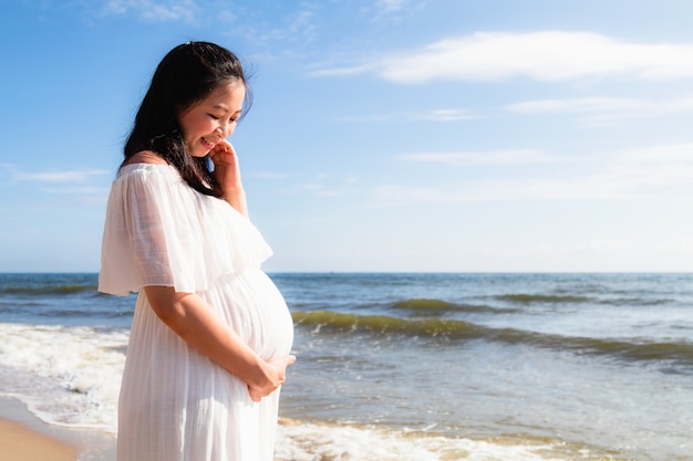 Aziatische zwangere vrouwen die zich dichtbij het overzees bevinden