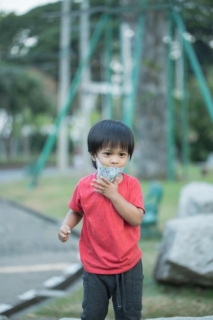 Azië kind glimlachend spelen op schuifbalk speelgoed buitenspeeltuin gelukkig voorschools klein kind dat grappig is tijdens het spelen op de speeltoestellen overdag in de zomer