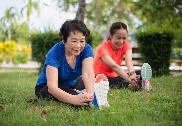 Azië senior en tiener vrouw training die zich uitstrekt in de tuin