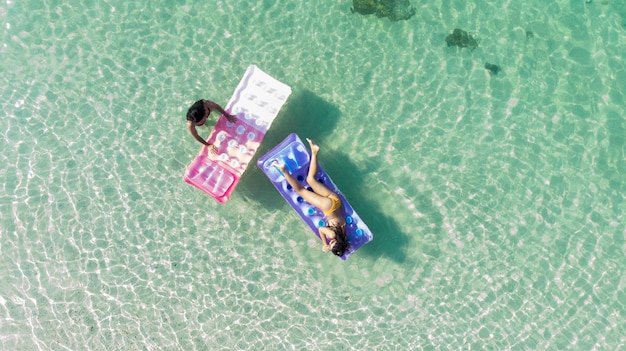 Azië vrouw ontspannen zonnebaden op de luchtbank in de prachtige groene zee