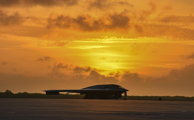 A b - 52 is parked on the tarmac at sunset