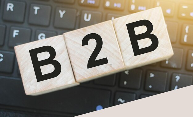 写真 ノート パソコンの前にある木製の立方体に書かれた b2b ビジネス ツー ビジネス コンセプト