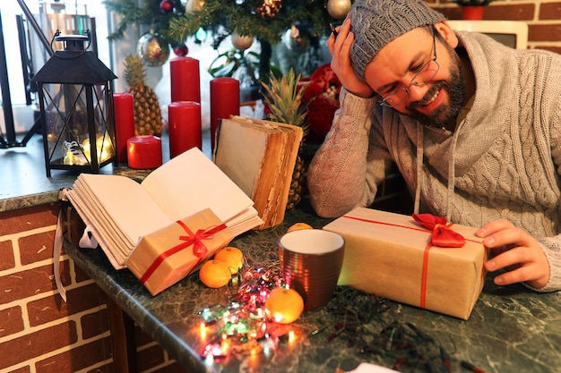 baard man kerstcadeaus schrijven op een tafel met oude boeken
