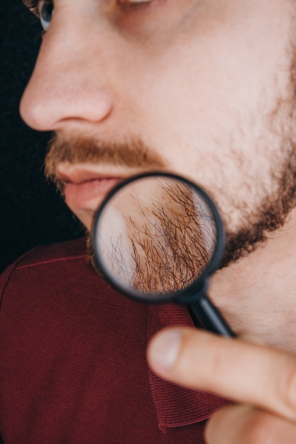 Baard onder een vergrootglas. haarlijn op het gezicht van een man close-up.