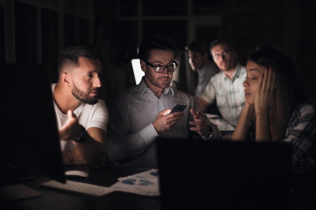 Baas kijkt naar het scherm van zijn smartphonestartup