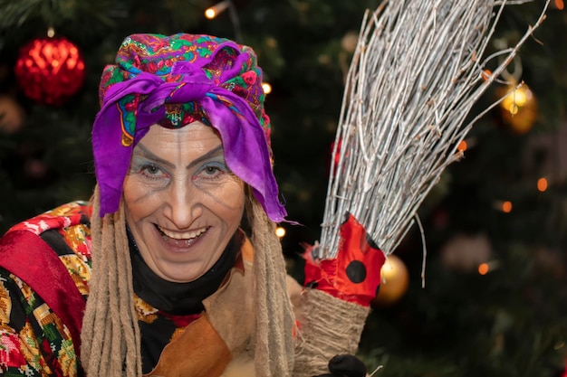 Baba Yaga with a broom on the background of the Christmas treeRussian witch