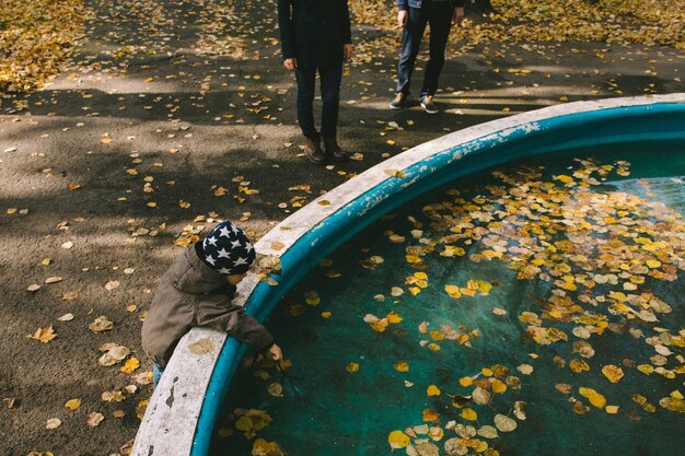 Baby aanraken van bladeren in het water herfst familie wandeling