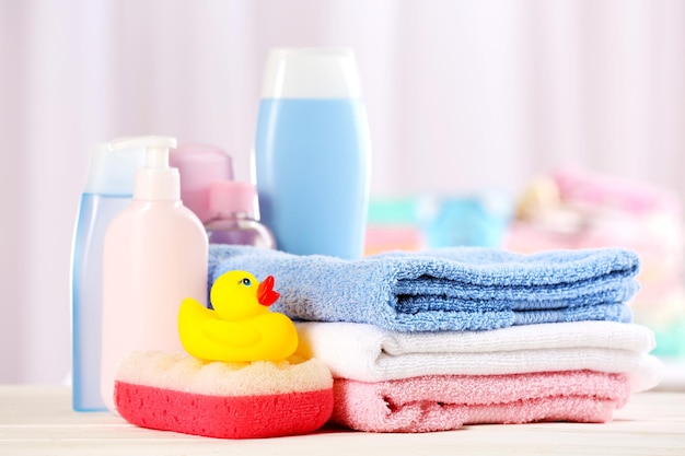 Baby accessories for bathing on table on light background