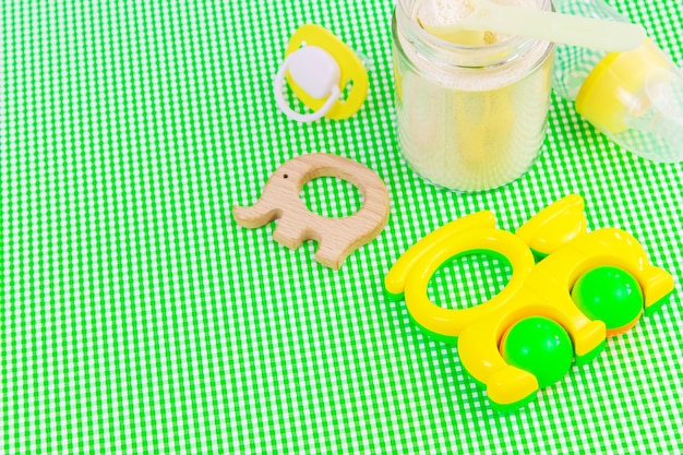 緑の背景にベビーアクセサリーや食品。セレクティブfocus.baby