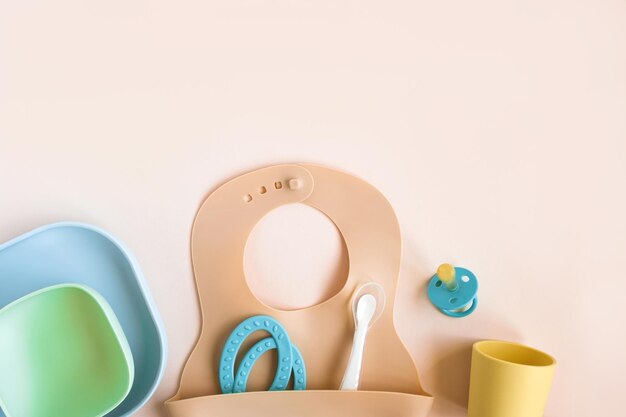 Foto accessori per bambini stoviglie per il cibo su sfondo beige prima alimentazione per bambini concept bib cup