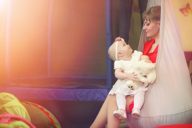 Baby in the arms of the girl. Mom holds her child in her arms. Happy mother with a little baby