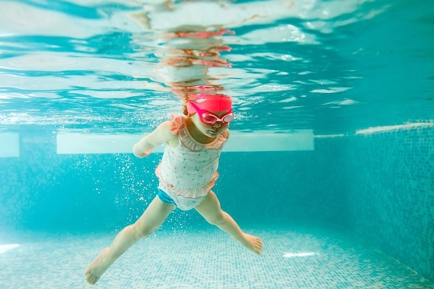 Foto sfondo del bambino. il bambino felice impara a nuotare, tuffati sott'acqua divertendoti in piscina per tenersi in forma. immersione.