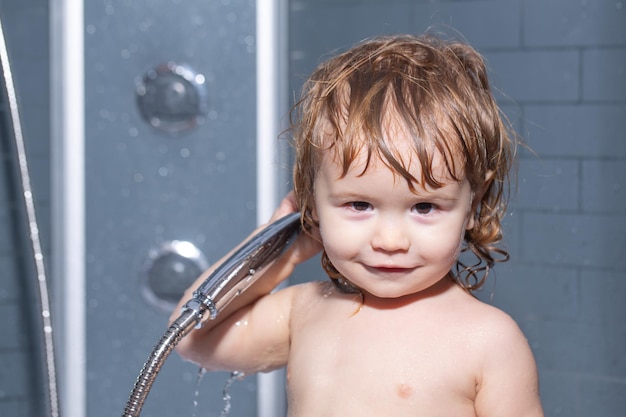 Baby bathes in a bath with foam and soap bubbles child bathing under a shower