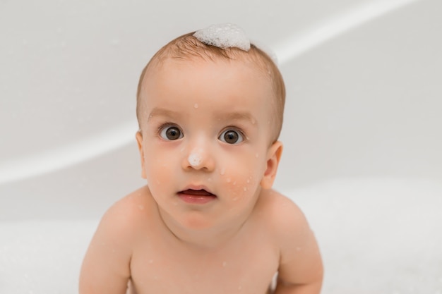 baby bathes in the bath with foam