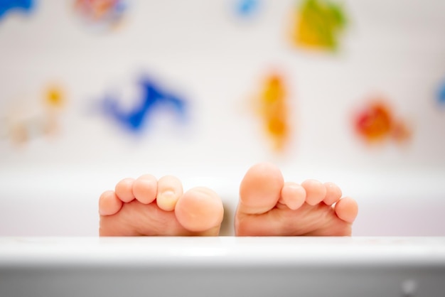 Baby in the bathroom Detail of cute wet feet covered with warm water