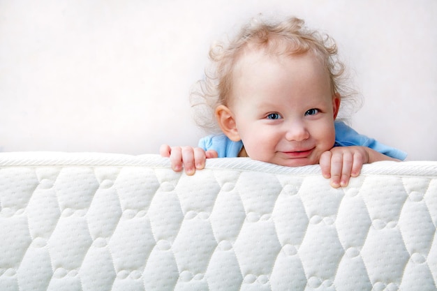 Photo baby on the bed mattress close-up. the sidewall of the mastras is stitched with finishing lines.