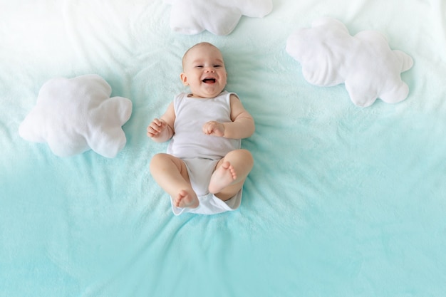 Baby on a blue sky background with clouds laughing