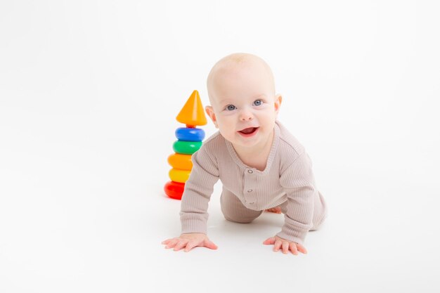 A baby in a bodysuit crawls on a white background studio shooting