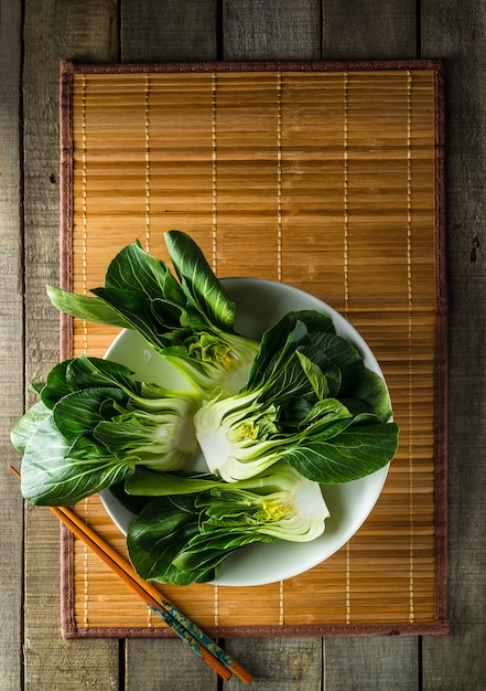 Baby bok choi op bamboe placemat op rustieke achtergrond