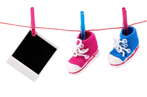 Photo baby bootees and photo hanging on the clothesline on a white background