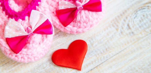 Baby booties and heart on a light background