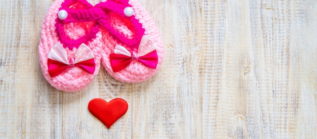 Baby booties and heart on a light background