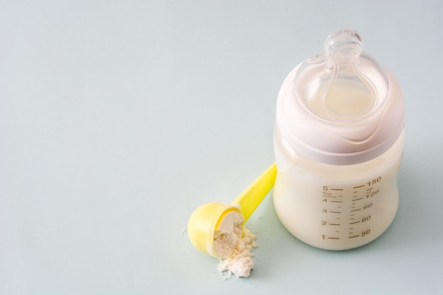 Photo baby bottle and milk on gray copy space