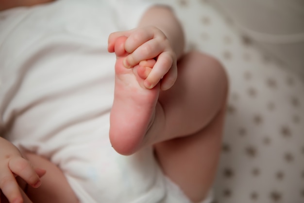 Bambino 5 mesi in una tuta bianca che giace in una vista dall'alto presepe