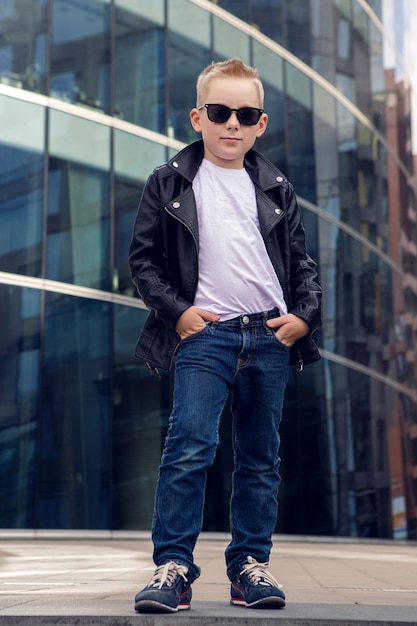 Photo baby boy 7 - 8 years in sunglasses and black leather jacket smiling