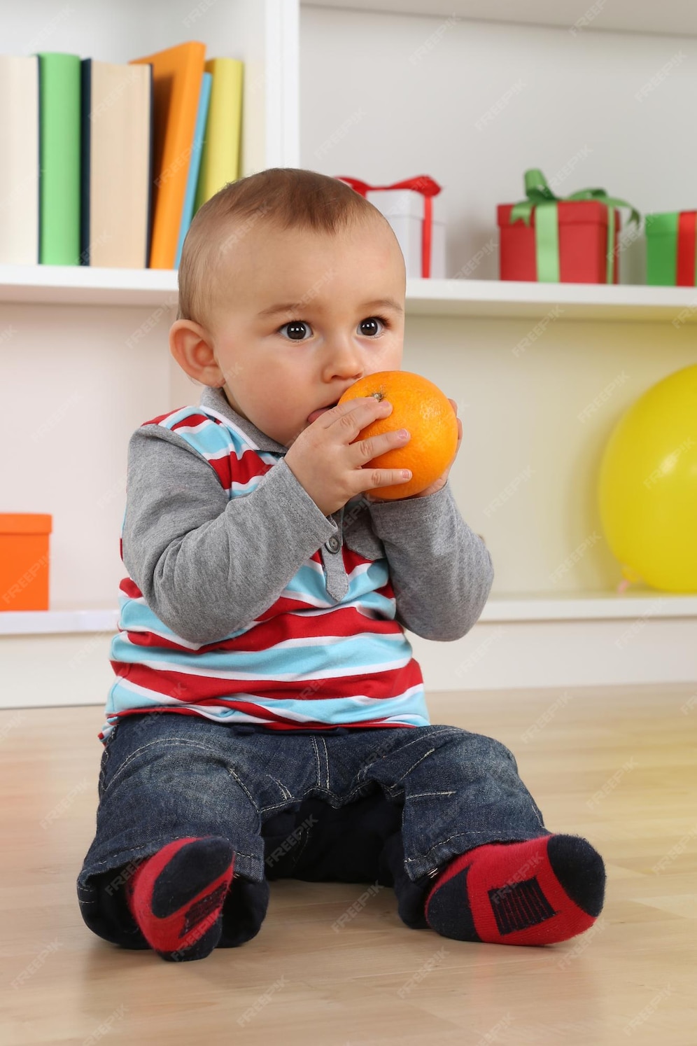 Premium Photo | Baby boy child eating orange fruit