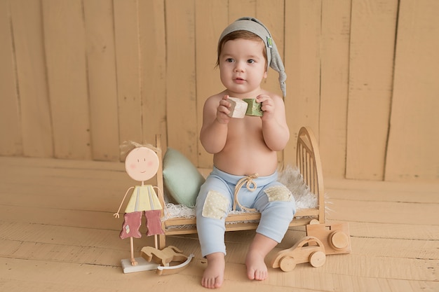 男の赤ちゃん 。子供の保護の日。幸せな子供時代。幼児の発達。教育木のおもちゃ。 。子供はおもちゃで遊ぶ。幸せな赤ん坊。