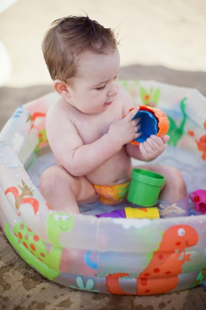 Baby boy in childs swimming pool