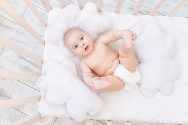 保育園のベビーベッドで男の子、かわいい面白い小さな赤ちゃん6ヶ月、健康的な睡眠の概念