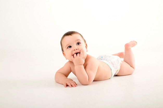 baby boy in diapers on white wall