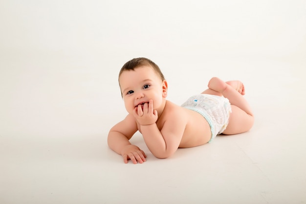 Photo baby boy in diapers on white wall