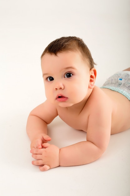 baby boy in diapers on white wall