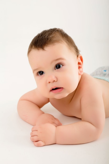 baby boy in diapers on white wall