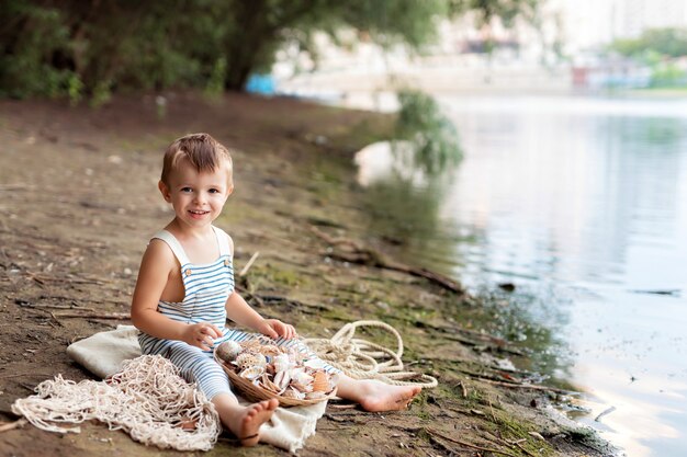 Baby boy dressed as a sailor on a sandy beach