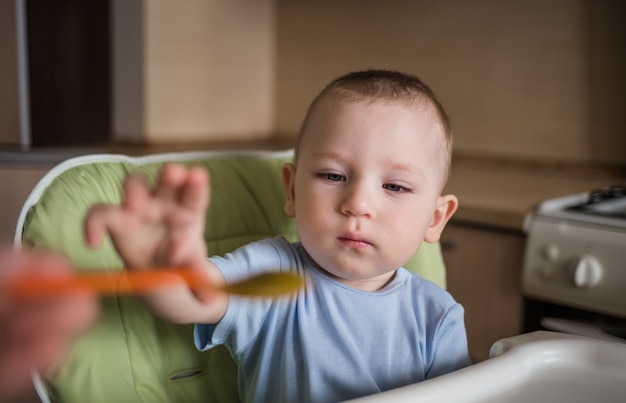 Baby boy eating in the kitchen